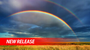 Rainbow over stormy sky. Rural landscape with rainbow over dark stormy sky in a countryside at summer day.